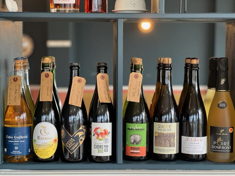 Sélection de cidres artisanaux bretons et normands présentée à la Crêperie Le Nazaire à Saint-Nazaire, mettant en valeur des bouteilles de producteurs du Morbihan, du Finistère et de Normandie.
